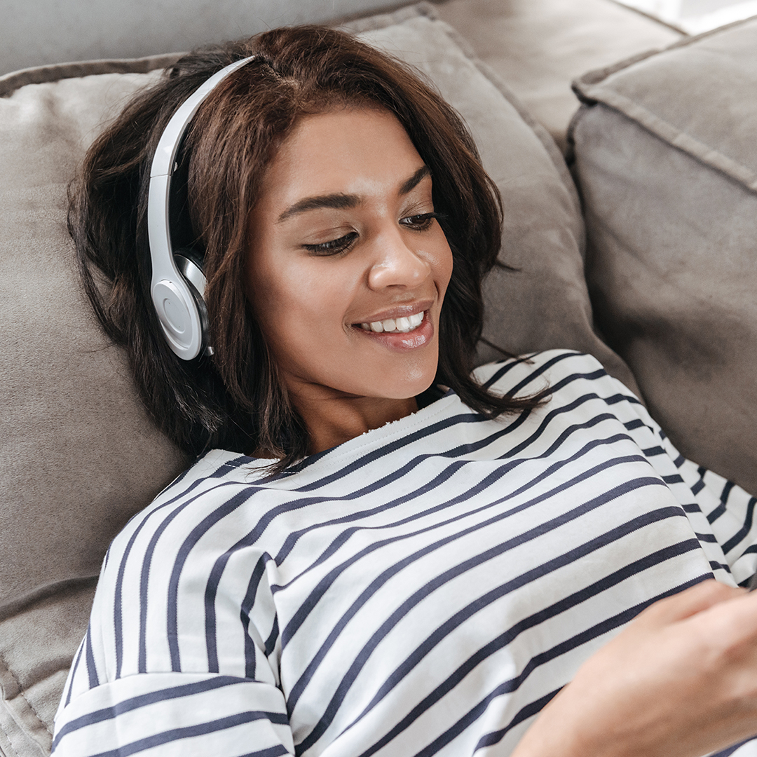 An image of a woman wearing headphones listening to a podcast